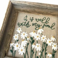 a cross stitch picture with daisies and the words it is well with my soul