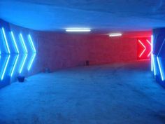 an empty parking garage with blue and red neon lights