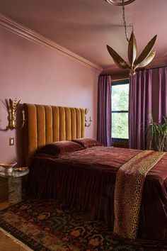 a bedroom with purple walls and a leopard print bed spread on the floor next to a window