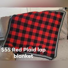 a red and black plaid blanket sitting on top of a couch