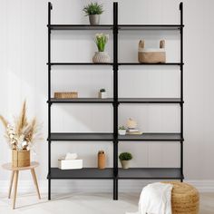 an empty room with white walls and shelves filled with plants, vases and bookshelves