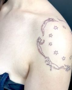 a woman with a tattoo on her shoulder that has stars in the shape of a crescent