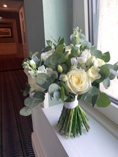 a bouquet of white flowers sitting on top of a window sill