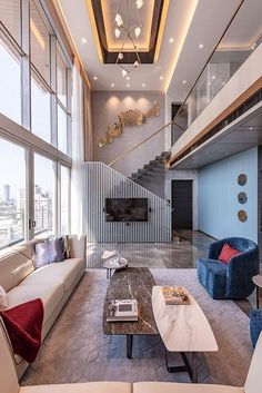 a living room with couches, tables and stairs in the background is an open floor plan