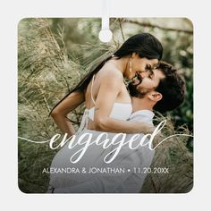 a photo ornament with the words engaged and an image of a couple kissing