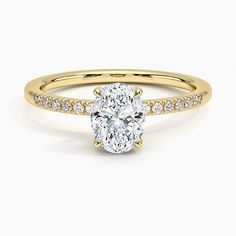 a yellow gold engagement ring with a oval cut diamond in the center and side stones