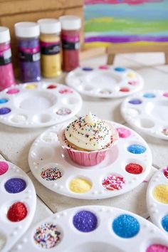 a cupcake on a plate with sprinkles and hearts in the background