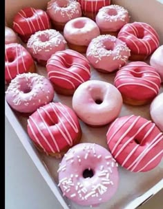 a box filled with lots of pink and white donuts