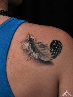 a woman with a feather tattoo on her shoulder