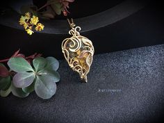 This Elven fantasy floral leaf necklace is wrapped in brass wire with Nellite Pietrsite.                                                                                                                                          It can be a unique decoration for a festive occasion or a lovely gift. Fantasy Necklace, Elven Jewelry, Gemstone Pendant Jewelry, Necklace Gothic, Unique Decoration, Jewelry Wire, Wire Wrapped Necklace, Leaf Necklace, Wrapped Pendant