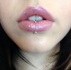 a close up of a woman's lips with glitter on her lip and nose ring