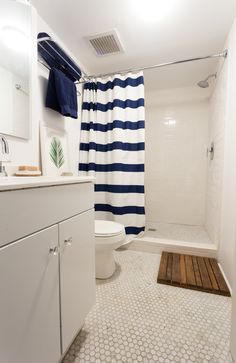 a white and blue striped shower curtain in a bathroom