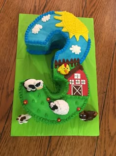 a cake shaped like the number five with farm animals on it