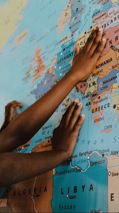 two people are writing on a map with their hands and feet touching each other's fingers