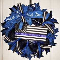 a blue and black wreath with an american flag in the center that says thank you, we support law enforcement