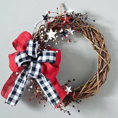 a patriotic wreath with red, white and blue bows on it sitting on a wall