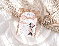 a minnie mouse birthday party is shown on a plate next to palm fronds