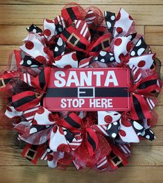 a santa stop here wreath on a wooden floor