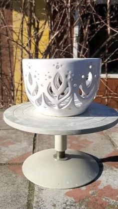 a white bowl sitting on top of a metal stand