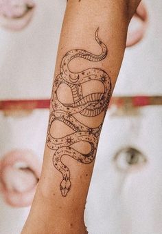 a woman's arm with a snake tattoo on it