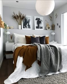 a bed with blankets and pillows on top of it in a bedroom next to a window