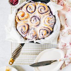 a table topped with a cake covered in icing next to plates and utensils