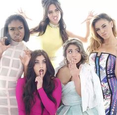 four beautiful women posing for the camera with their hands on their lips and one holding her mouth open