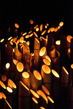 many candles are lit in the dark with small circles on them, and one is surrounded by smaller ones