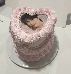 a heart shaped cake with a woman's face in the middle