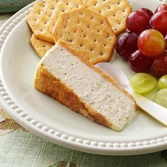 a white plate topped with grapes and crackers