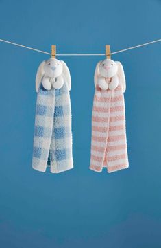 two towels hanging on a clothes line with one holding a stuffed animal