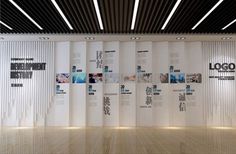 an empty room with white partitions and wooden floors in front of the wall that has pictures on it