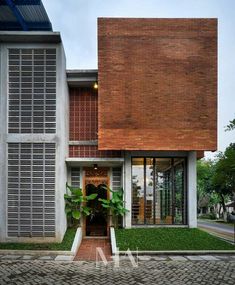 a brick building with lots of windows and grass on the ground in front of it