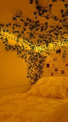 there is a bed covered in vines with lights on the headboard and wall behind it