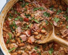 a pot filled with beans, ham and greens