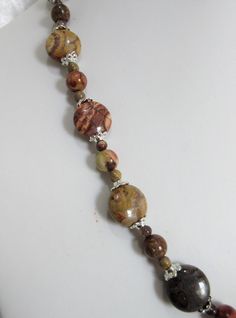 "Birdseye rhyolite jasper is a beautiful, unusual, brown gemstone. Occasional eye-like swirls of brown beige and rust colors run through the stone. The pendant is charming! The necklace is 18\" long with a 3\" silver plated extender. The pendant is a 1.5\" oval. The beads are 4mm rounds, 8mm rounds, and 14mm flat rounds. Silver tone bead caps encase the larger beads. All beads are birdseye rhyolite jasper. The earrings hang 1\" from the loop of the silver plated ear wires. This set will be slipp Turquoise Jewelry Set, Brown Gemstone, Jasper Jewelry, Brown And Beige, Agate Jewelry, Jasper Pendant, Oval Pendant, Hand Made Jewelry, Bead Caps