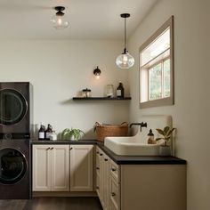 a washer and dryer in a small room with wood flooring on the walls