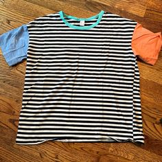 Blue And Orange With Stripped Black And White Top. Does Have A Slight Bleach Stain On Right Arm Multicolor Horizontal Stripe Tops For Spring, Blue Summer T-shirt With Horizontal Stripes, Blue Horizontal Stripe T-shirt For Summer, Summer Blue T-shirt With Contrast Stripes, Blue Striped Summer T-shirt, Blue Striped T-shirt For Summer, Sporty Striped Summer T-shirt, Casual T-shirt With Striped Hem For Spring, Blue Vertical Striped T-shirt For Summer