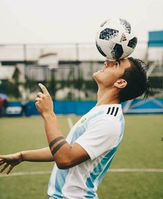 a young man tossing a soccer ball on top of his head