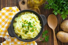 potatoes and mashed potatoes with parsley in a black bowl on a wooden table