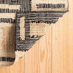 an area rug with black and white stripes on top of wooden flooring next to a door