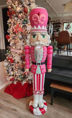 a large nutcracker standing next to a christmas tree