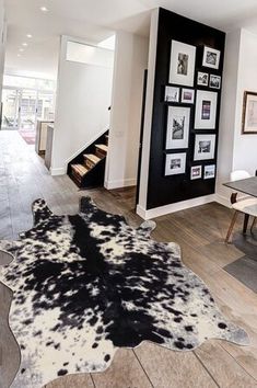 a large cowhide rug is in the middle of a dining room table and chairs