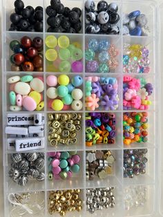 a plastic container filled with lots of different colored beads and buttons on top of each other