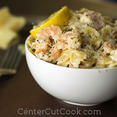 a white bowl filled with food next to a fork