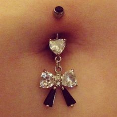 a close up of a woman's belly with an attached navel ring and clear crystal heart