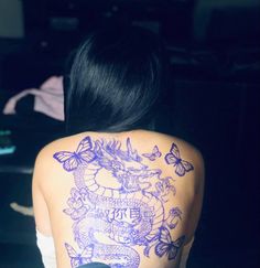 the back of a woman's shoulder with tattoos and butterflies on her upper half