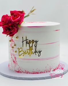 a birthday cake decorated with pink and white frosting, gold lettering and two red roses