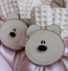 two white teddy bears with pink bows on their head and ears, sitting next to each other