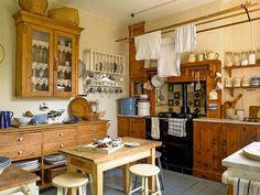 an old fashioned kitchen with wooden cabinets and dishes on the counter top, along with other appliances